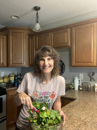 Penny in her kitchen prepping a healthy salad