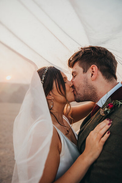 couple kiss under veil