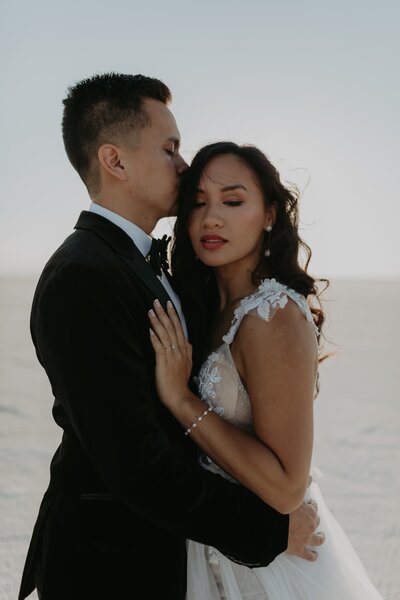 groom kissing brides forehead