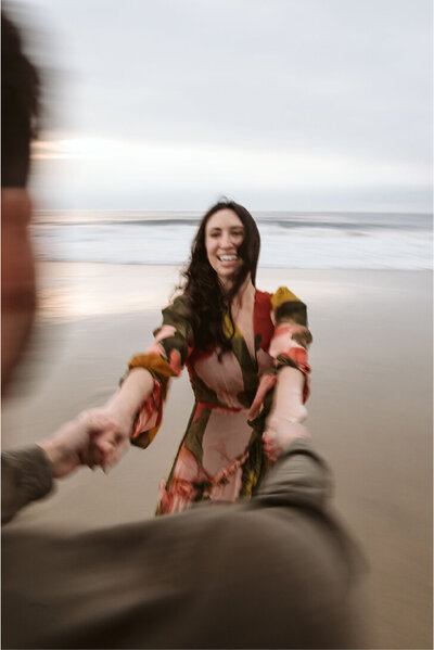 couple spinning on beach and smiling
