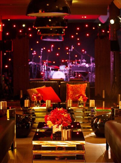 Event setup with red flowers and black and gold decor.