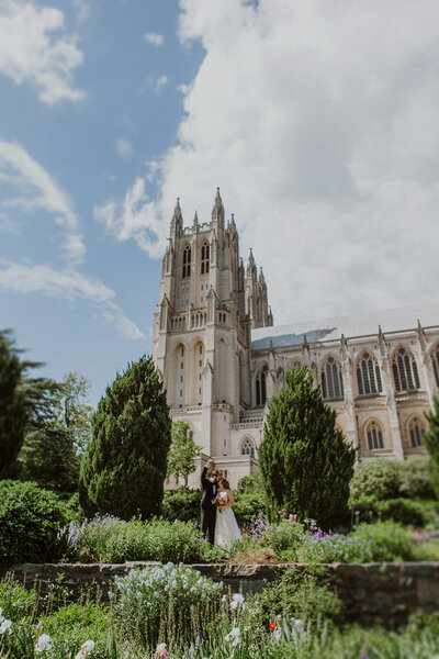 Bride and Groom embrace in gardens next to the National Cathedral in DC