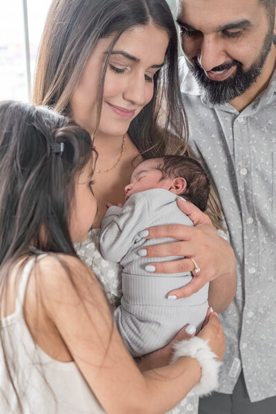 Lifestyle newborn photography session with dad holding baby's toes — captured by Alliston and Barrie maternity, newborn, and family photographer.
