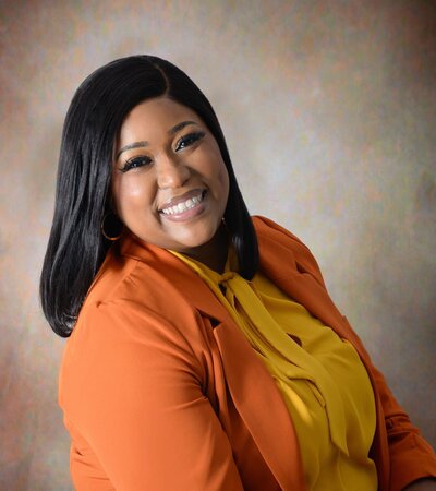 Women’s career coaching session focused on achieving professional goals, with a career coach working at a desk, using a laptop and motivational materials to guide clients toward success.