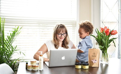 woman on laptop with son looking on