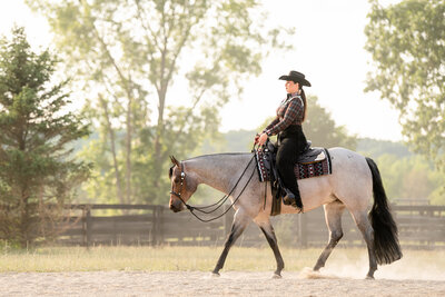 Wynnewood Oklahoma horse trainers Amanda and Nick of Topwind Ranch stand together between their two chestnut Quarter Horses. Amanda is looking up at Nick while embracing his arm.
