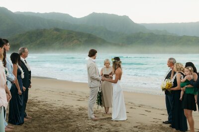 bridge and groom saying vows on beach