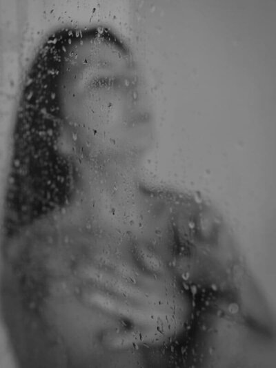 Zwartwit boudoir portret van vrouw in douche