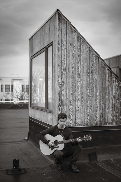 Skylar kergil plays guitar on rooftop in boston