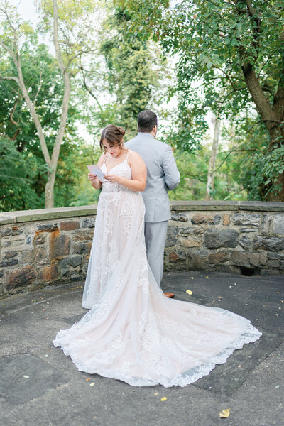 Bride and groom reading letters with their backs to each other