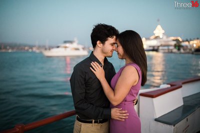 Tender moment between engaged couple on the ferry crossing over Balboa Island
