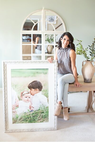 Philadelphia Newborn Photographer Ashley Blair posing with large framed portrait
