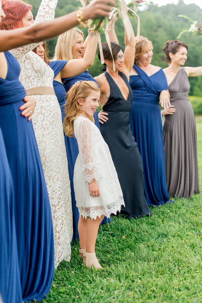 Wedding party photo in West Jefferson, NC of bridesmaids and a flower girl laughing.