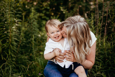 Portrait of mom kissing one year old son's cheek during photography session