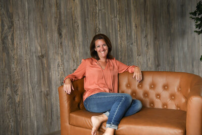 Jess sitting on a couch in her studio