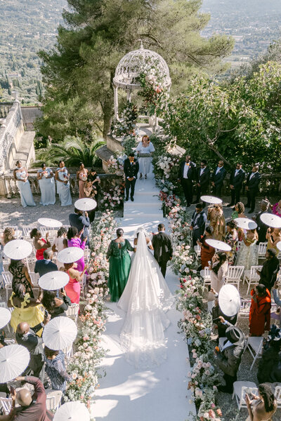 Elegant bride and groom standing hand in hand in a sunlit stone courtyard in the Chateau de Naudou South of France — Portfolio Thomas Raboteur Wedding Photographer.
