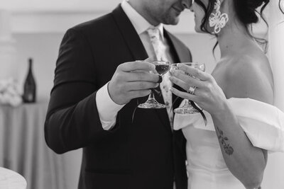 Husband and wife clinking their champagne glasses after saying their "I dos" and enjoying their time as newlyweds during their reception party.
