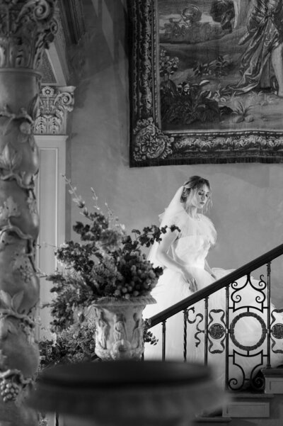 A jewel-toned floral arch sits on a stage for a wedding ceremony.