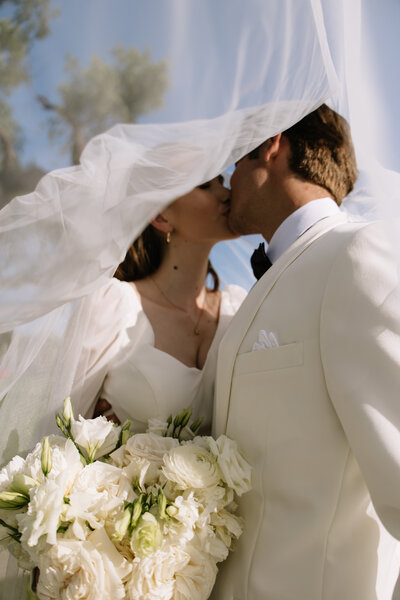 Payton and Evan kissing under her veil.