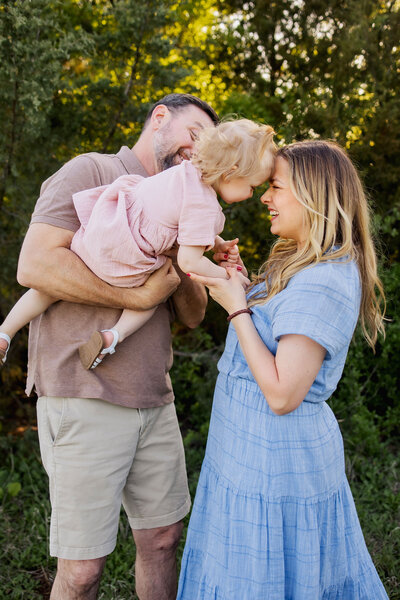 family of three smile at a photo session in plano texas