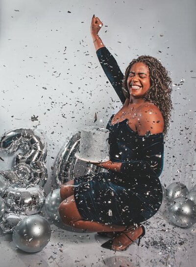 free-photo-of-a-woman-in-a-black-dress-holding-a-cake-and-confetti