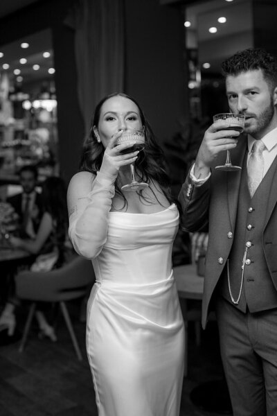 Bride and groom at wedding reception drinking coctials