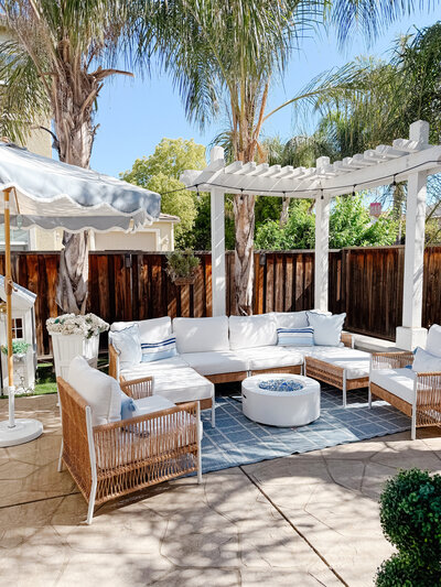 a backyard with outdoor couches and a fire pit