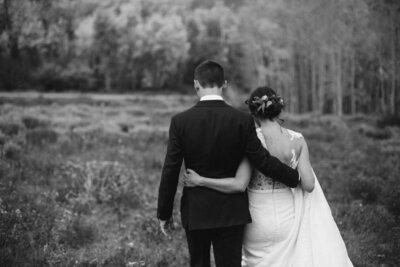 couple walking in field after wedding