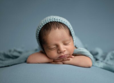 Baby boy sleeping on his tummy on a blue blanket. Studio newborn photoshoot in Woodstock GA