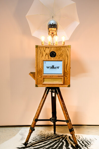 Vintage photo booth with bulbs, umbrella, flash in front of a nude backdrop