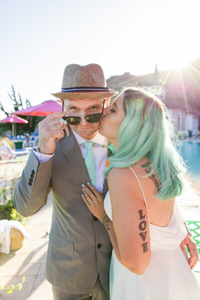 bride kisses her groom wearing sunglasses