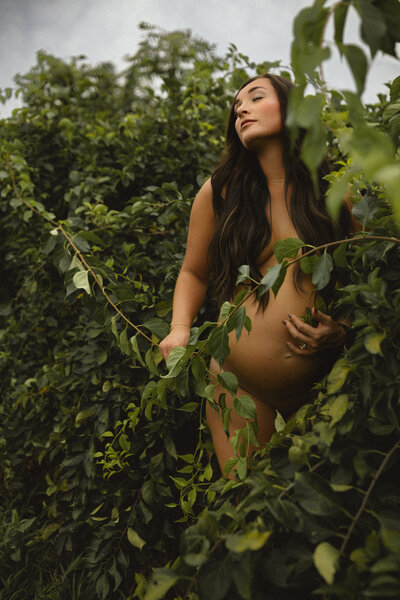 Pregnant mother shaking her hair in the bright Ames, IA sun.