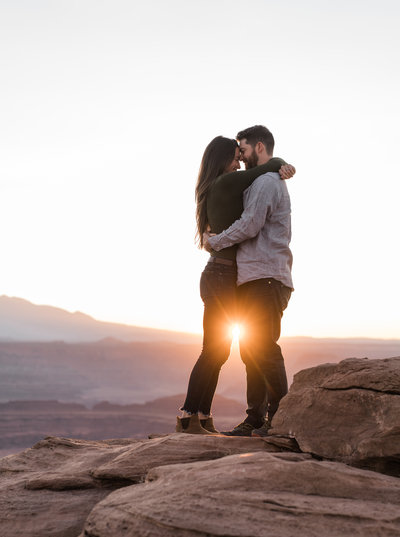 man and woman standing on rock hugging
