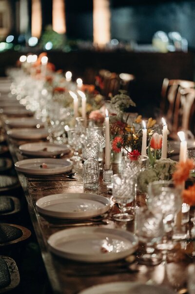Candlelit tablescape with red flowers at a wedding in Mexico