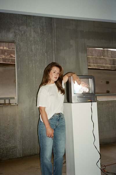 woman posing by TV