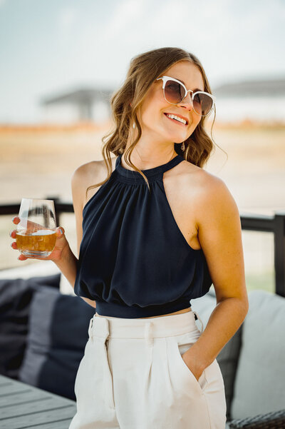 Woman outside with sunglasses and drink in hand