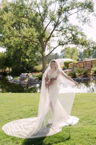 Bride underneath her cathedral length veil for a stylized bridal portrait at a garden wedding venue in colorado