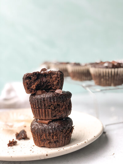 Stack of 3 paleo chocolate zucchini muffins on a plate