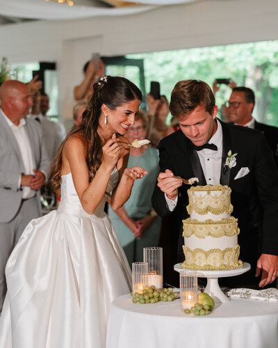 Elegant wedding cake cutting at Greencrest Manor in Battle Creek, Michigan