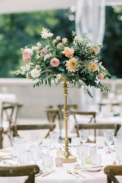 Charming outdoor wedding reception with stunning floral design by Leigh Florist featuring white and blush flower arrangements.
