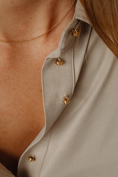 kaboompics_details-of-gold-jewelry-beautiful-woman-wearing-a-tan-silk-shirt-28073