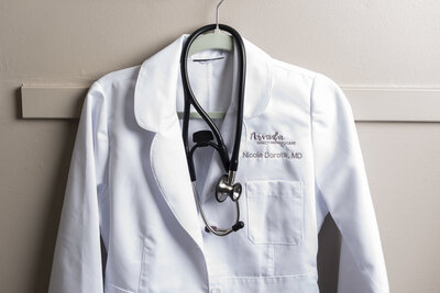 a white medical doctor coat hanging up