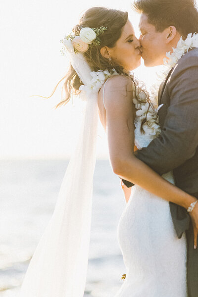 Groom carries bride along a rainy Oregon Coast wedding in tones of grey