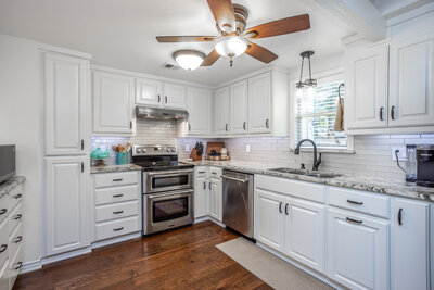 white kitchen with granite countertops  in Big beautiful home for sale in Lindsay Texas with a dreamy inground pool