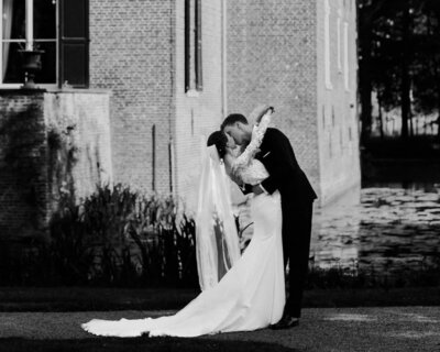 Bruid en bruidegom die elkaar liefdevol aankijken tijdens hun bruiloft, gecoördineerd door een weddingplanner.