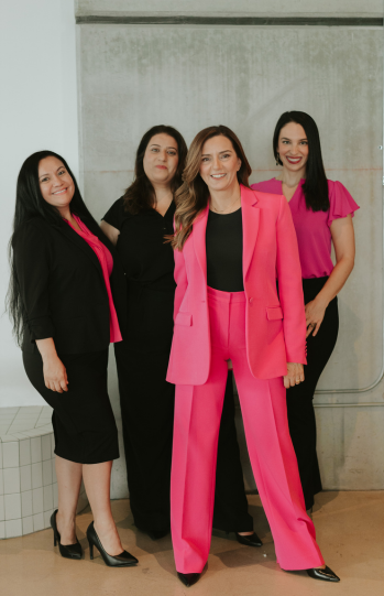 The Relationship Experts team of licensed marriage and family therapists standing together in coordinated pink and black outfits, representing professionalism, compassion, and expertise in couples therapy and affair recovery.