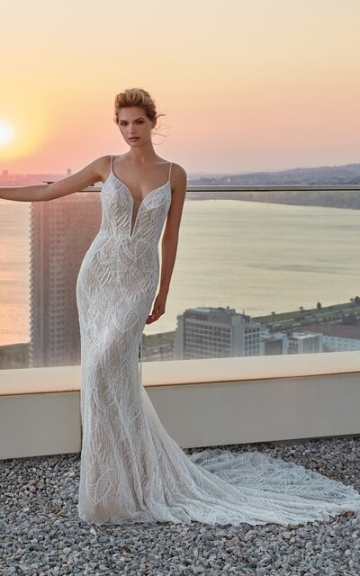 Looking to show off your shoulders and collarbones? This sophisticated crepe sheath bridal dress features an off-the-shoulder neckline and lacy straps to help you do just that.