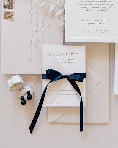 Black silk robbon bow tied around an rsvp envelope