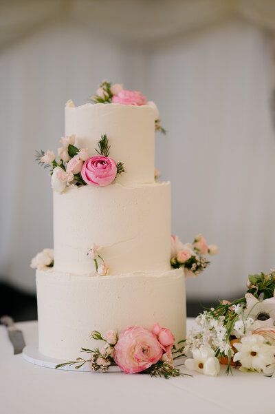 White wedding cake decorated with pink flowers