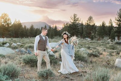 A bride and groom walk through Tuolumne Meadows in Yosemite National Park. 